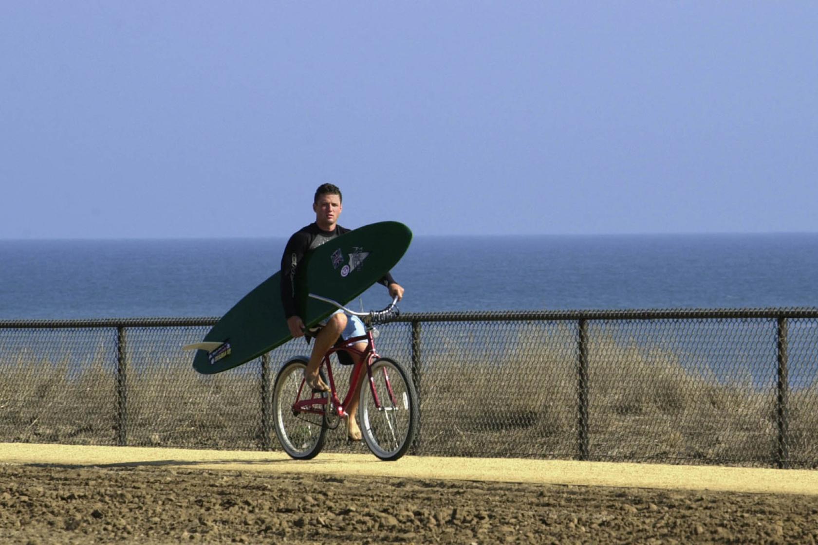 surfer riding a bike near Manzanita Villages