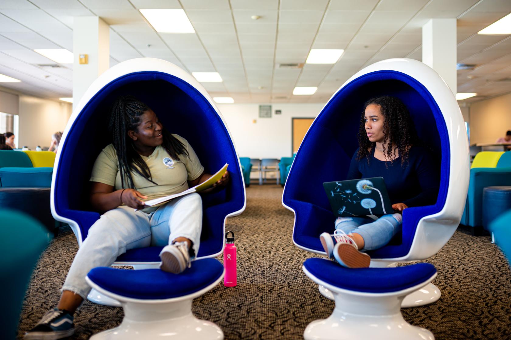 students sitting on egg chair in lounge